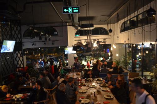 a group of people sitting at a table in a restaurant at Tuzla Town Hotel in Tuzla