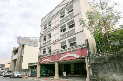 un edificio blanco y rojo con un letrero. en Super OYO 406 Royale Parc Inn & Suites, en Manila