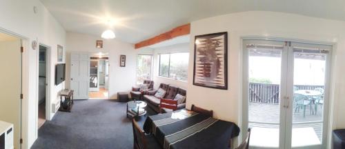 a living room with a couch and a balcony at Haven on Haven in Moeraki