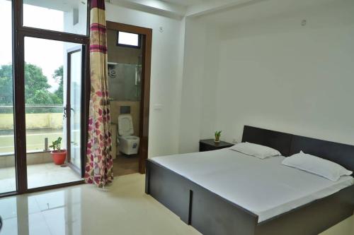 um quarto com uma cama e uma grande janela em Best Properties In Rishikesh em Rishikesh
