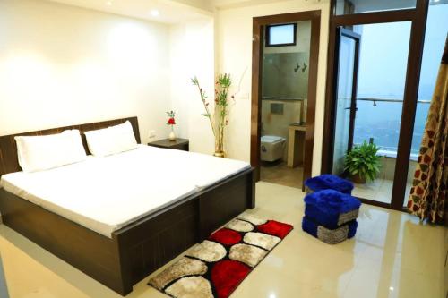 a bedroom with a large bed and a large window at The Most Beautiful Property Of Rishikesh in Rishīkesh
