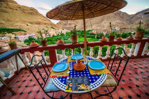 - une table sur un balcon avec un parasol dans l'établissement Riad Sephora, à Tinghir