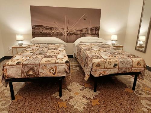 two beds in a hotel room with two beds at Affittacamere Monumentale in Genova