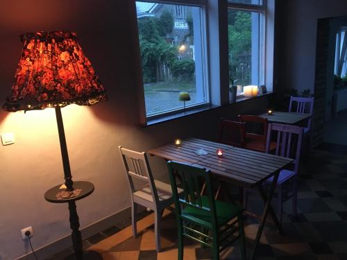 uma mesa com cadeiras e um candeeiro num quarto em Liotte'sCorner Guesthouse em Sprimont