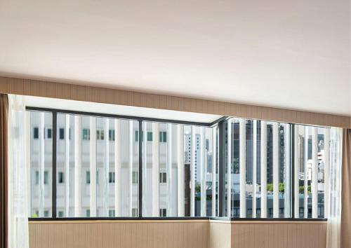 a large window in a building with tall buildings at Eleven Hotel Bangkok Sukhumvit 11 in Bangkok