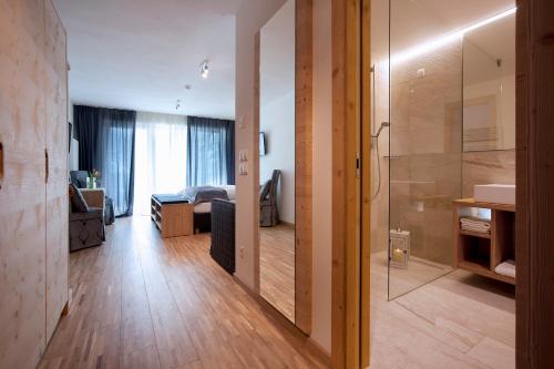 a room with a bathroom and a living room at Hotel Italia in Corvara in Badia