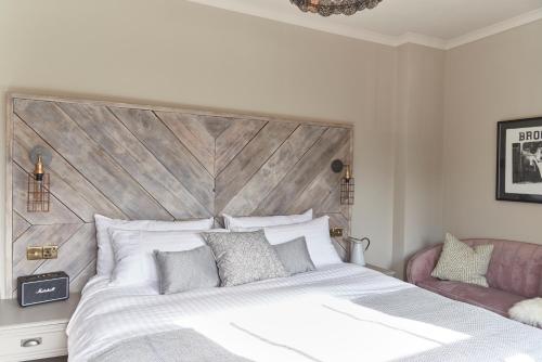 a bedroom with a large bed with a wooden headboard at The Lodge Duxford in Duxford