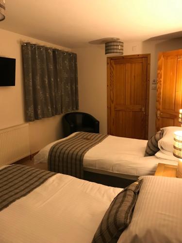 a hotel room with two beds and a window at Ardconnel Bed and Breakfast in Kirkwall
