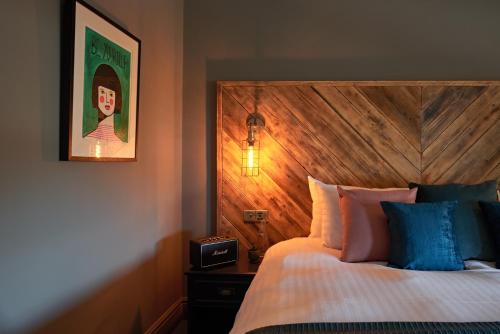 a bedroom with a bed with a wooden head board at The Lodge Duxford in Duxford