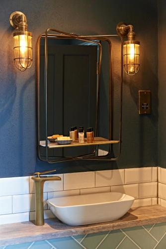 a bathroom with a sink and a large mirror at The Lodge Duxford in Duxford