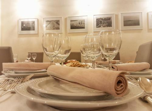 a table with wine glasses and plates on it at Antica Masseria Torre Mozza in Torre Santa Susanna