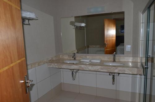 Un baño con dos lavabos y un espejo. en Sakr Hotel Rio Preto, en São José do Rio Preto