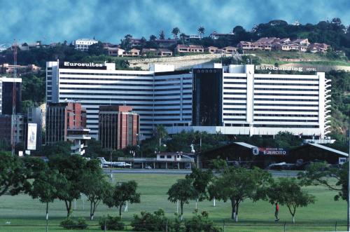 um grande edifício branco com árvores em frente a uma cidade em Eurobuilding Hotel & Suites Caracas em Caracas