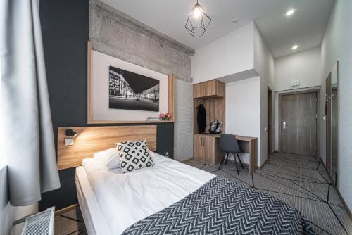 a bedroom with a bed and a desk in it at Amarant Urban Hotel by CHM in Kyiv