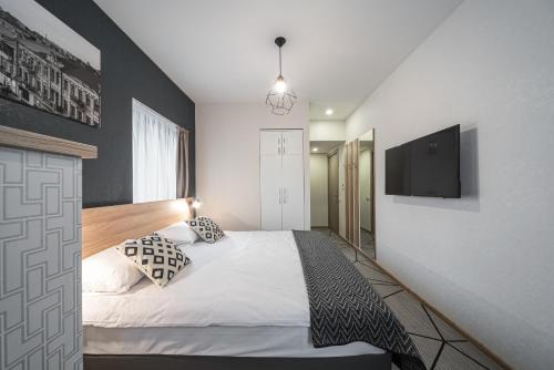 a bedroom with a bed and a flat screen tv at Amarant Urban Hotel by CHM in Kyiv