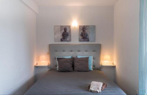 sypialnia z łóżkiem z dwoma obrazami na ścianie w obiekcie Akivillas Quarteira Relax II w mieście Quarteira