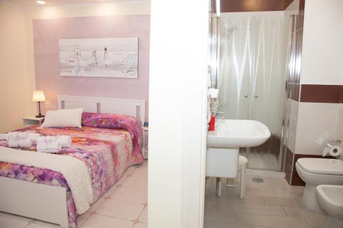 a bedroom with a bed and a bathroom with a sink at b&b Napoli Capitale in Naples