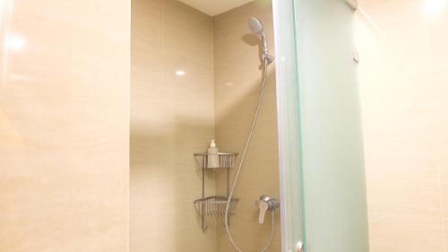 a shower with a shower head in a bathroom at Galeri Ciumbuleuit 3 by AYA Stays in Bandung