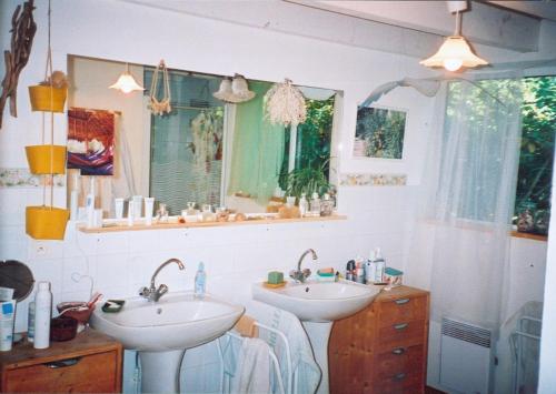 a bathroom with two sinks and a mirror at Les Villas de Messanges in Messanges