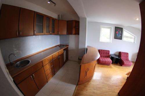 a kitchen with wooden cabinets and red chairs at Villa D&L in Ohrid