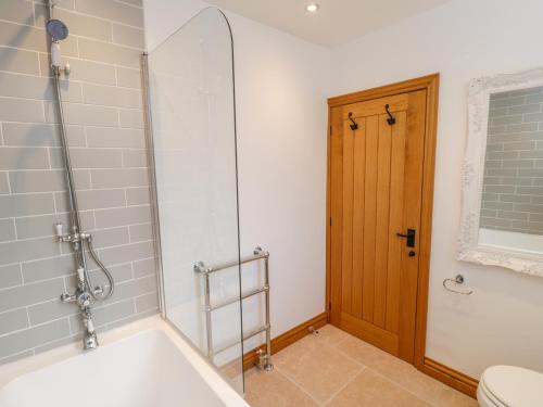 ein Bad mit einer Badewanne, einer Dusche und einem WC in der Unterkunft Cherry Cottage in Whitby