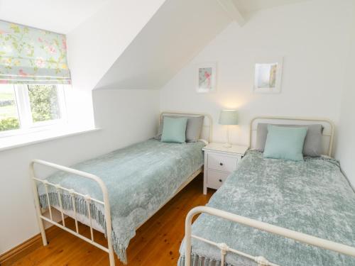 a bedroom with two beds and a window at Cherry Cottage in Whitby