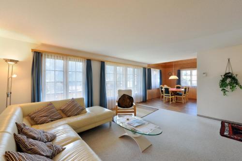 ein Wohnzimmer mit einem Sofa und einem Tisch in der Unterkunft Apartments Kirchbühl in Grindelwald