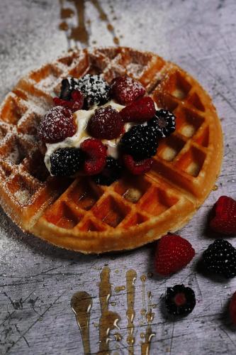 a waffle with berries and cream on a table at Malmaison Edinburgh City in Edinburgh