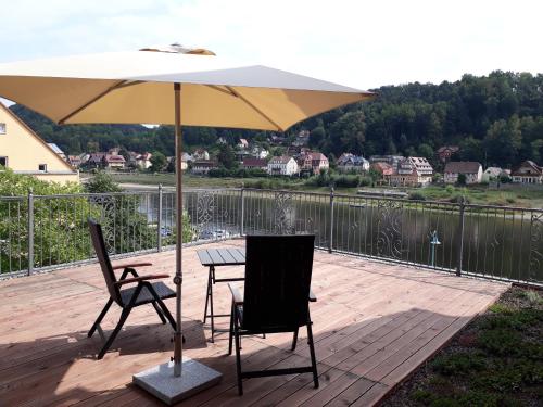 a table and two chairs under an umbrella on a deck at Dampfschiffhotel in Stadt Wehlen