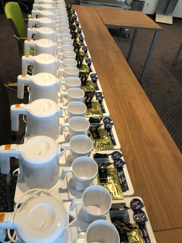 a long table filled with cups and teapots at Hotel Peterchens Mondfahrt in Fulda