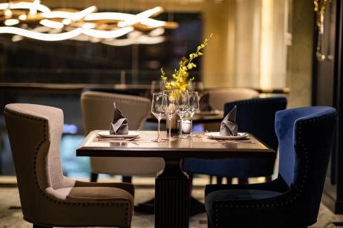 a table in a restaurant with chairs and wine glasses at Soleil Boutique Hotel Hanoi in Hanoi