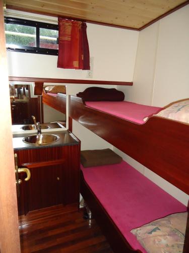a small room with two bunk beds and a sink at Klipper De Hoop in Akkrum