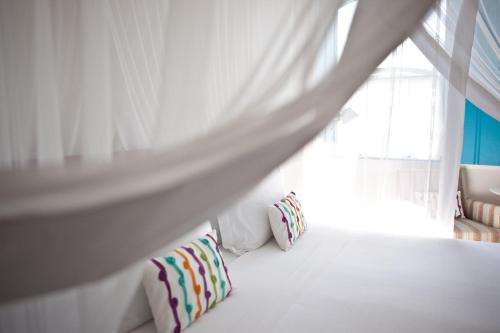 a bedroom with a bed with pillows and a window at Casa Turquesa - Maison D´Hôtes in Paraty