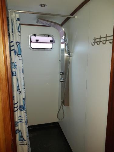 a shower in a train room with a curtain at Klipper De Hoop in Akkrum