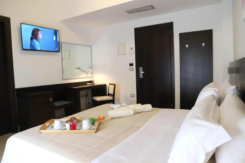 a hotel room with a bed with a tv on the wall at Albergo Cantiani in Ancona