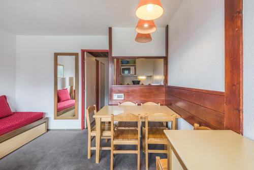 une cuisine et une salle à manger avec une table et des chaises dans l'établissement Residence Les Fontaines Blanches - maeva Home, à Avoriaz