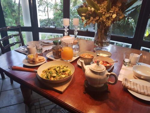 a table with a bowl of food and a pitcher of orange juice at The Great Gatsby Houghton in Johannesburg