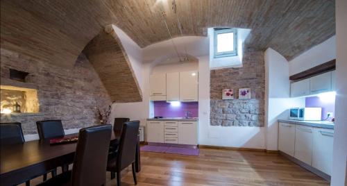 een keuken en eetkamer met een stenen muur bij Appartamento Sant'Apollinare in Assisi