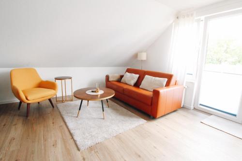 a living room with a couch and a table and a chair at Ostseeblick Sassnitz in Sassnitz