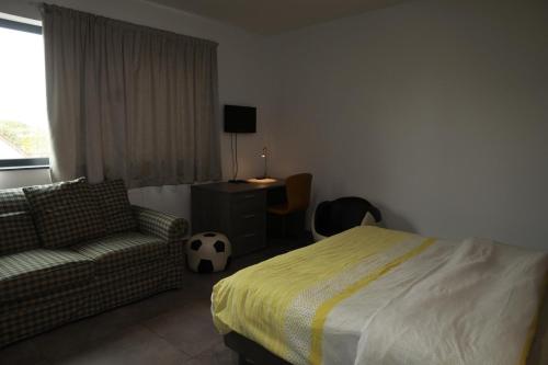 a bedroom with a bed and a couch and a desk at Résidence la floraison in Brussels