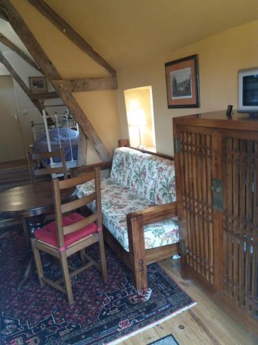 a living room with a couch and a chair at La Berlandière in Le Merlerault
