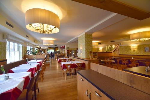 a restaurant with tables and chairs in a room at Hotel&Wirtshaus Sonne in Weyregg