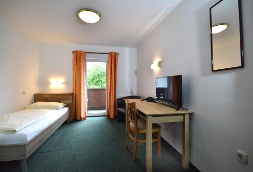 Zimmer mit einem Bett und einem Schreibtisch mit einem Computer in der Unterkunft Hotel&Wirtshaus Sonne in Weyregg