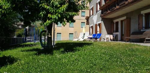 a group of chairs sitting on a lawn in front of a building at Baita al Pian in Bormio
