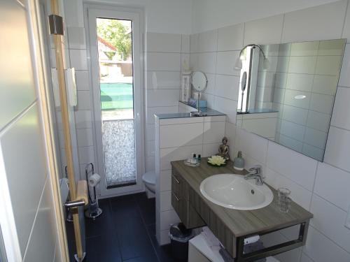a bathroom with a sink and a mirror at TiWu - Ferienwohnungen in Steinhude