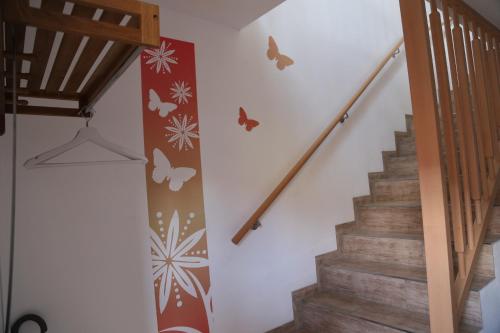 a staircase with butterflies stenciled on the wall at Ferienwohnung Memmel in Sulzfeld (im Grabfeld)