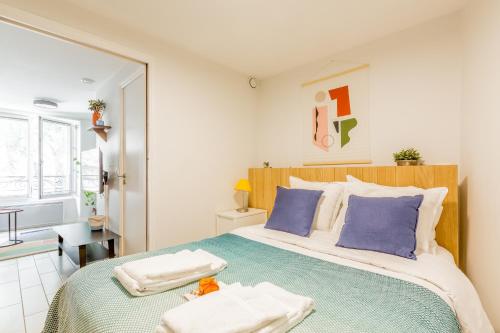 une chambre avec un grand lit avec des oreillers bleus dans l'établissement Résidence Louvre - Bellan, à Paris