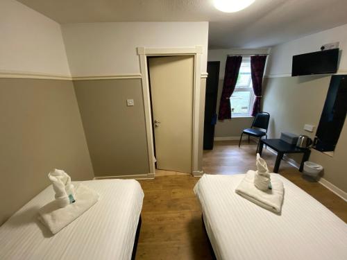 a room with two beds with towels on them at Auld Mill House Hotel in Dunfermline