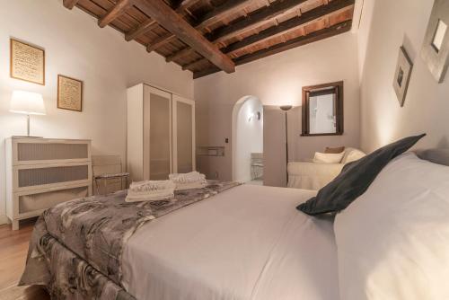 ein Schlafzimmer mit einem großen weißen Bett in einem Zimmer in der Unterkunft Fori Imperiali Elegant Apartment in Rom