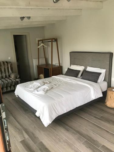 a bedroom with a large bed with white sheets and pillows at Ktima Faki, Olympus Mountain Accommodation & Retreat in Litochoro